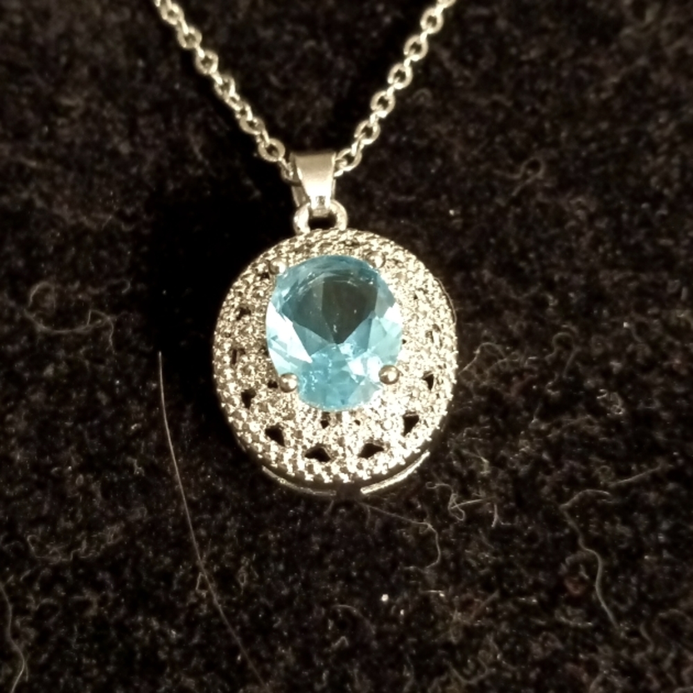 Blue topaz color stone necklace in an oval pendant.